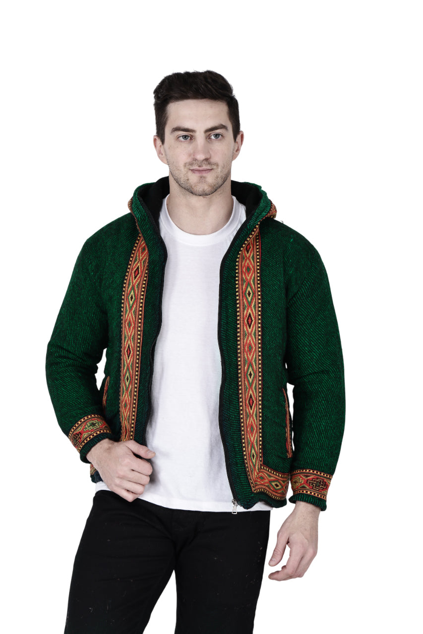 himachali hoodie for men kullu hoodie himachali hoodie kullu hoodie for men kullu hoodie for men A man wears the aruna kullu handloom Woolen Winter Wear ZIPPER HOODIE in green with a patterned border, styled over a white t-shirt and black pants, standing against a white background.