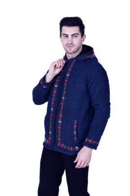 A man wearing a blue aruna kullu handloom Kullu hoodie jacket for men with colorful Kullu Patti trim stands against a white background.