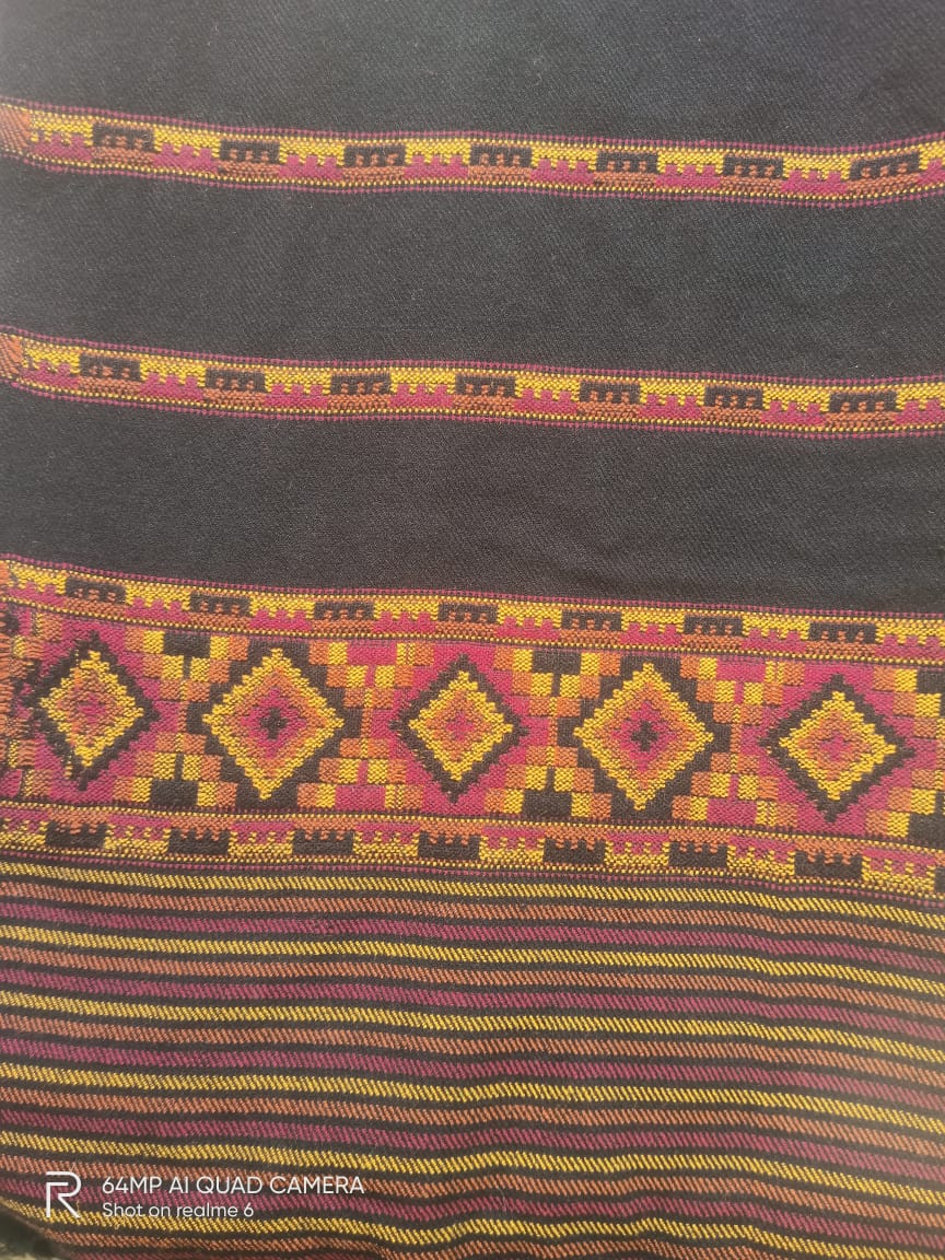 A close-up of the aruna kullu handloom Hand Woven PASHMINA BLACK Shawl for women, featuring intricate geometric embroidery in yellow, pink, orange, and purple on a dark base, with diamonds and stripes showcasing its rich texture.