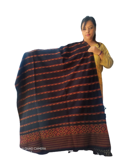 A woman in a yellow sweater displays the aruna kullu handloom Hand Woven PASHMINA BLACK Shawl, featuring red and orange stripes and an embroidered geometric border, against a plain white background.