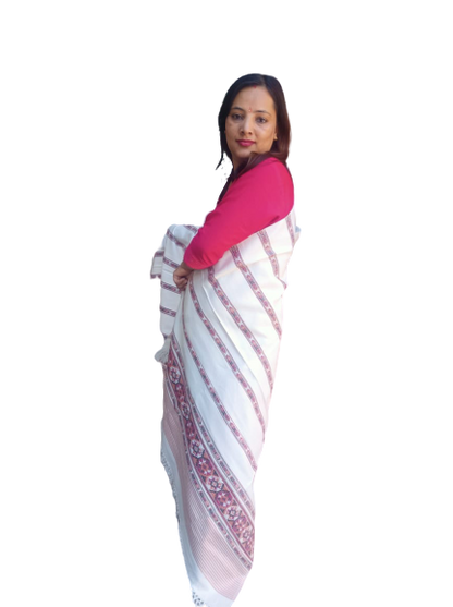 A woman with straight dark hair stands sideways, wearing a red long-sleeve top and an Aruna Kullu Handloom hand woven PASHMINA WHITE shawl with beautiful embroidery, against a plain white background.