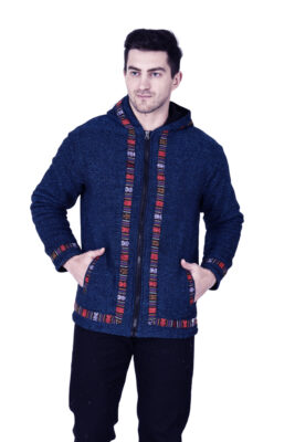 A man stands with his hands in the pockets of an aruna kullu handloom Kullu hoodie jacket for MEN BLUE, featuring colorful Kullu patti trim on the zipper, hood, cuffs, and hem, set against a white background.