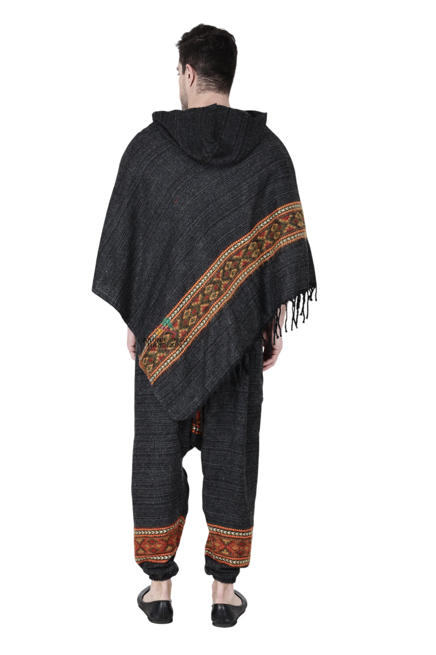 A person models the aruna kullu handloom Combo pajama and poncho black singal patti, featuring colorful handwoven embroidery, paired with matching winter woolen pajamas and black slip-on shoes, set against a white background.