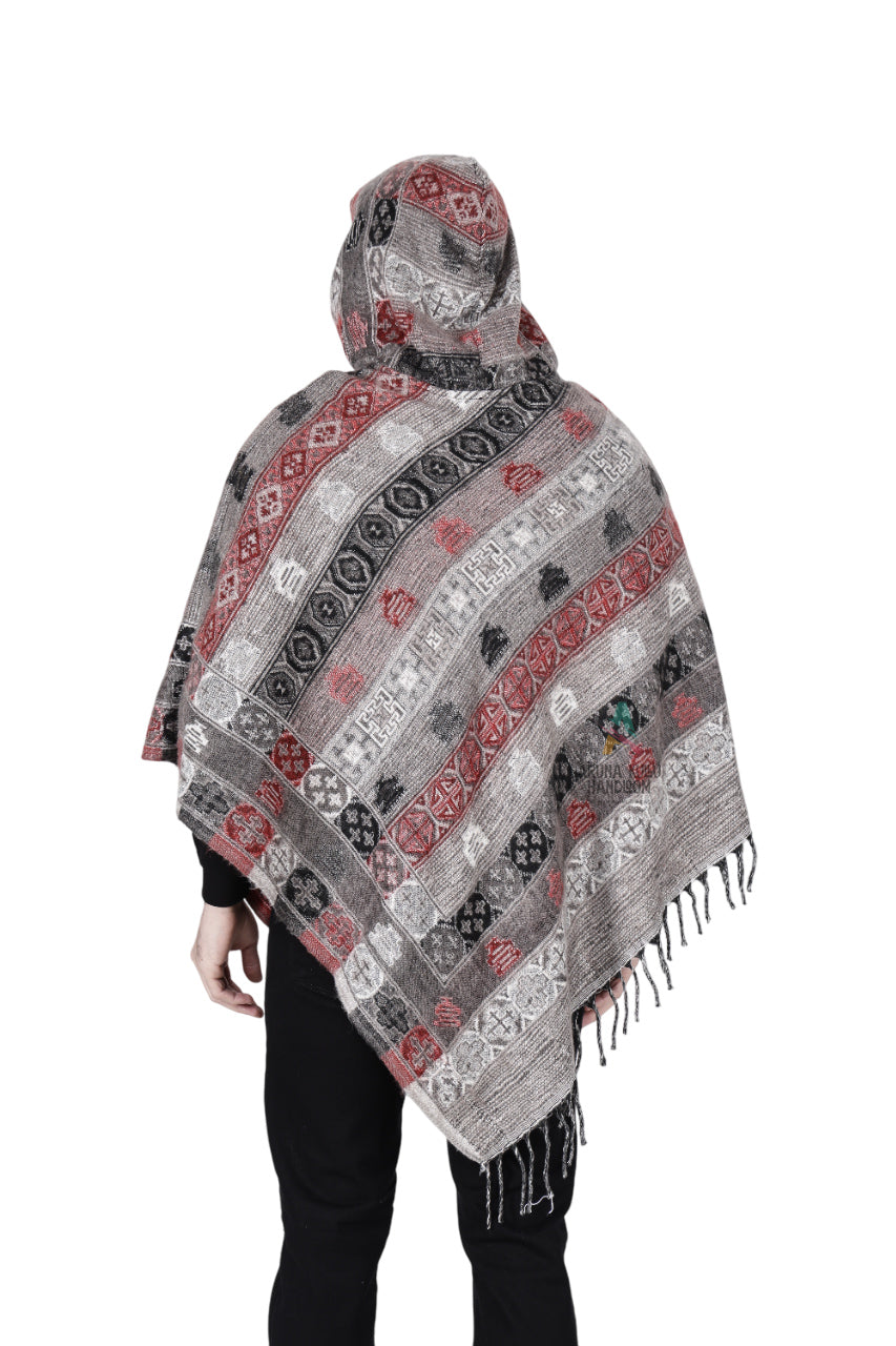 A person is shown from the back wearing the aruna kullu handloom kullu shawl woolen poncho with hood for men in grey, featuring striped patterns, fringe along the bottom edge, and draping over the arms and upper body.
