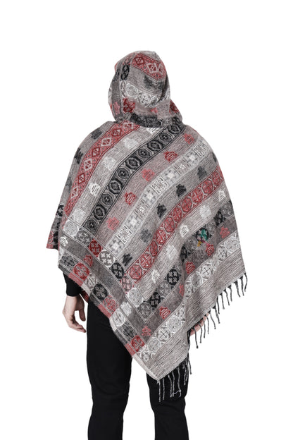 A person is shown from the back wearing the aruna kullu handloom kullu shawl woolen poncho with hood for men in grey, featuring striped patterns, fringe along the bottom edge, and draping over the arms and upper body.
