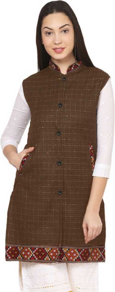 A woman wearing the "Check brown long jacket with kullu lace work" by aruna kullu handloom over a white long-sleeve top and white pants.