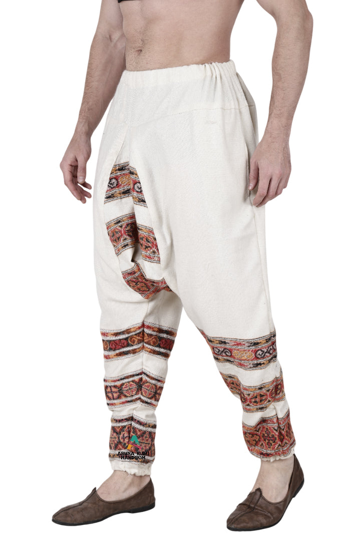 A man wears aruna kullu handloom's yoga pajama for men loose white 3 patti with patterned stripes, paired with brown shoes and no shirt.