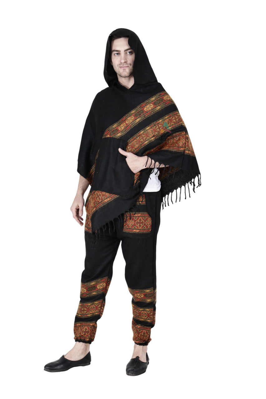 A person wears the black "Combo pajama and poncho 3 patti" by aruna kullu handloom, featuring colorful orange and brown patterned bands, standing against a white background.