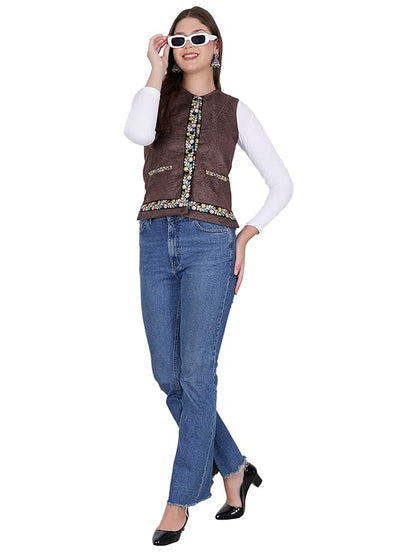 A woman in a white long-sleeve top, aruna kullu handloom Nehru jacket women with embroidery work (coffee), blue jeans, black heels, and white sunglasses poses confidently with one hand touching her sunglasses.