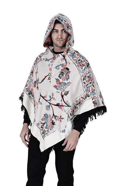 A man with short dark hair models the aruna kullu handloom Shimla jacket price kullu shawl woolen poncho with hood kashmiri silver over a black outfit, standing against a white background.Pahadi poncho for men pahadi kullu poncho mens kullu woolen poncho himachali poncho for men Himachali poncho online