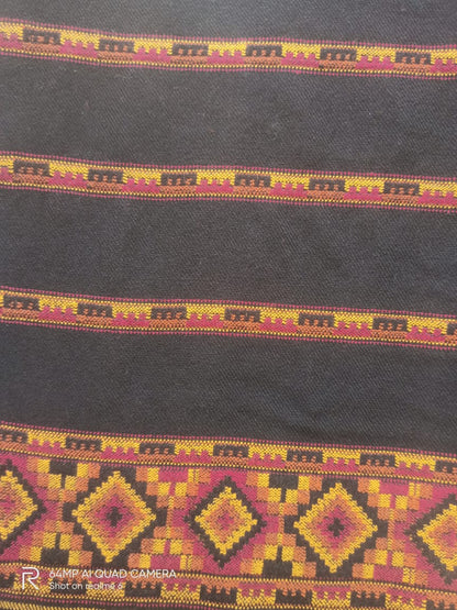 A close-up of the Hand Woven PASHMINA BLACK Shawl by aruna kullu handloom, featuring colorful geometric embroidery in yellow, red, and orange on dark wool fabric—showcasing traditional ethnic patterns for women.