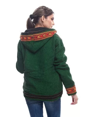 A person with brown hair in a ponytail wears an aruna kullu handloom green ZIPPER HOODIE Jacket for MEN & Women with kullu patti work, paired with blue jeans, standing back to the camera against a white background.kullu patti hoodies online kullu patti hoodies kullu hoodie woolen kullu woolen hoodies kullu hoodie for girls