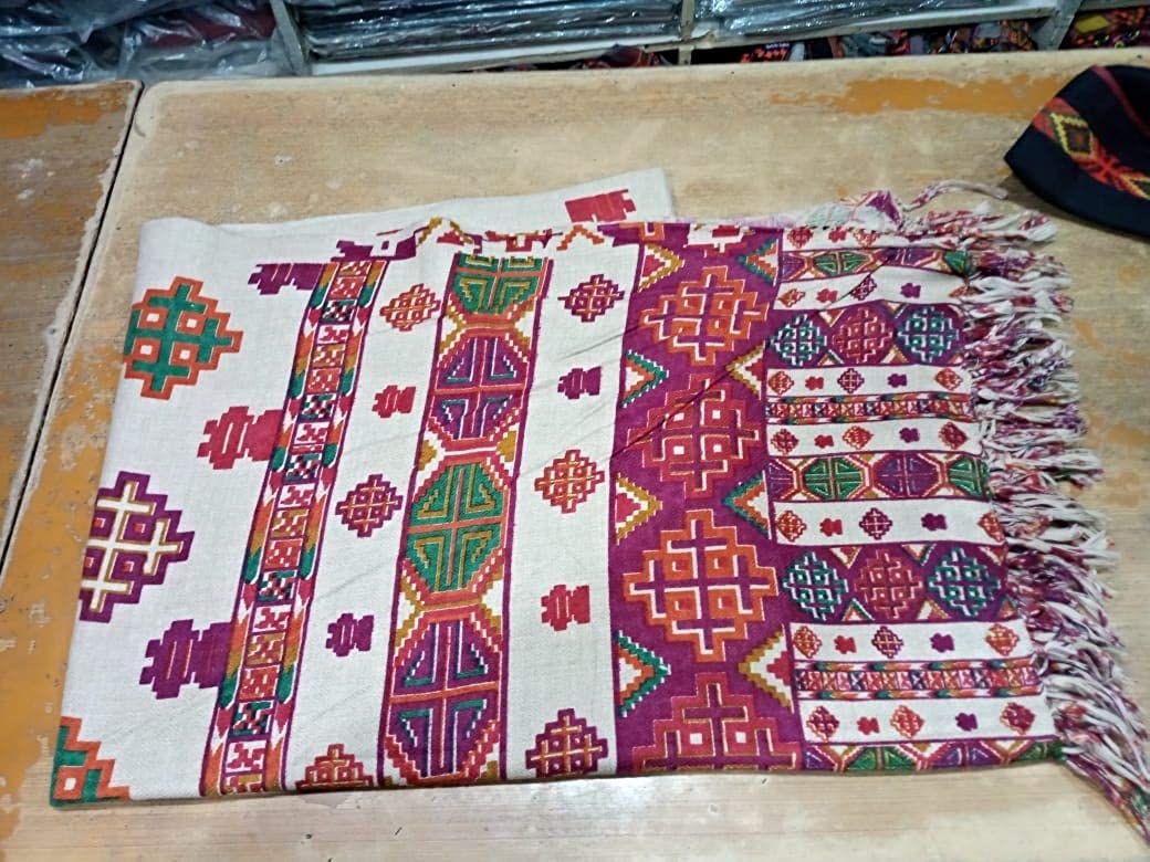 kinnauri shawl kullu and kinnauri shawls kinnauri shawls online kinnauri shawls history  The aruna kullu handloom Pure Yak Wool Pashmina Kinnauri Triple Border printed shawl features vibrant geometric patterns in red, green, purple, and orange on beige, with fringed ends—echoing traditional Kinnauri craftsmanship.