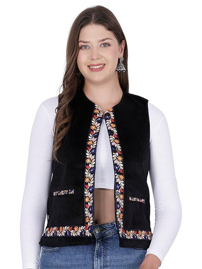 himachali jacket himachali sadri for ladies sadri for women kullu jacket for ladies winter sadri for women kullu jacket himachali half jacket for ladies  A smiling woman with long brown hair wears the aruna kullu handloom Nehru jacket for women in black, featuring embroidery work along the edges and pocket openings. She styles it over a white long-sleeve shirt and blue jeans.