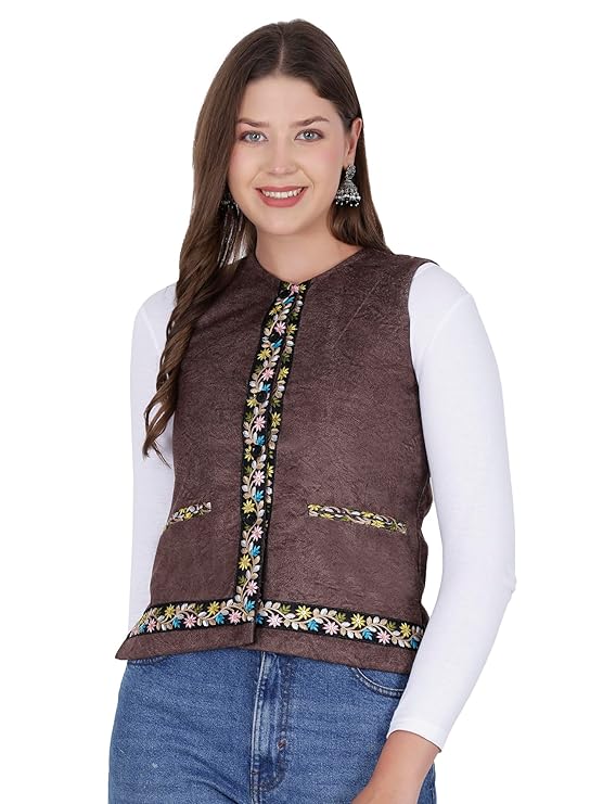 A woman with long brown hair wears a white long-sleeve top, blue jeans, and an aruna kullu handloom Nehru jacket for women with embroidery work in coffee, smiling at the camera against a white background.