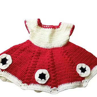 The woolen baby frock (0-12 months) by Aruna Kullu Handloom features a red and white crocheted design with a flared skirt, white bodice, hand woven embroidery trim, and three black and white circular star accents near the hem.