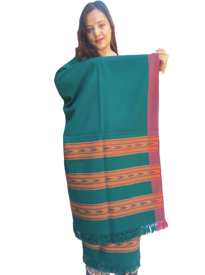 A woman holds an aruna kullu handloom ANGORA Shawl for women, featuring beautiful triple border Kullu weaving in green with red and yellow geometric patterns and fringed edges, set against a plain white background.