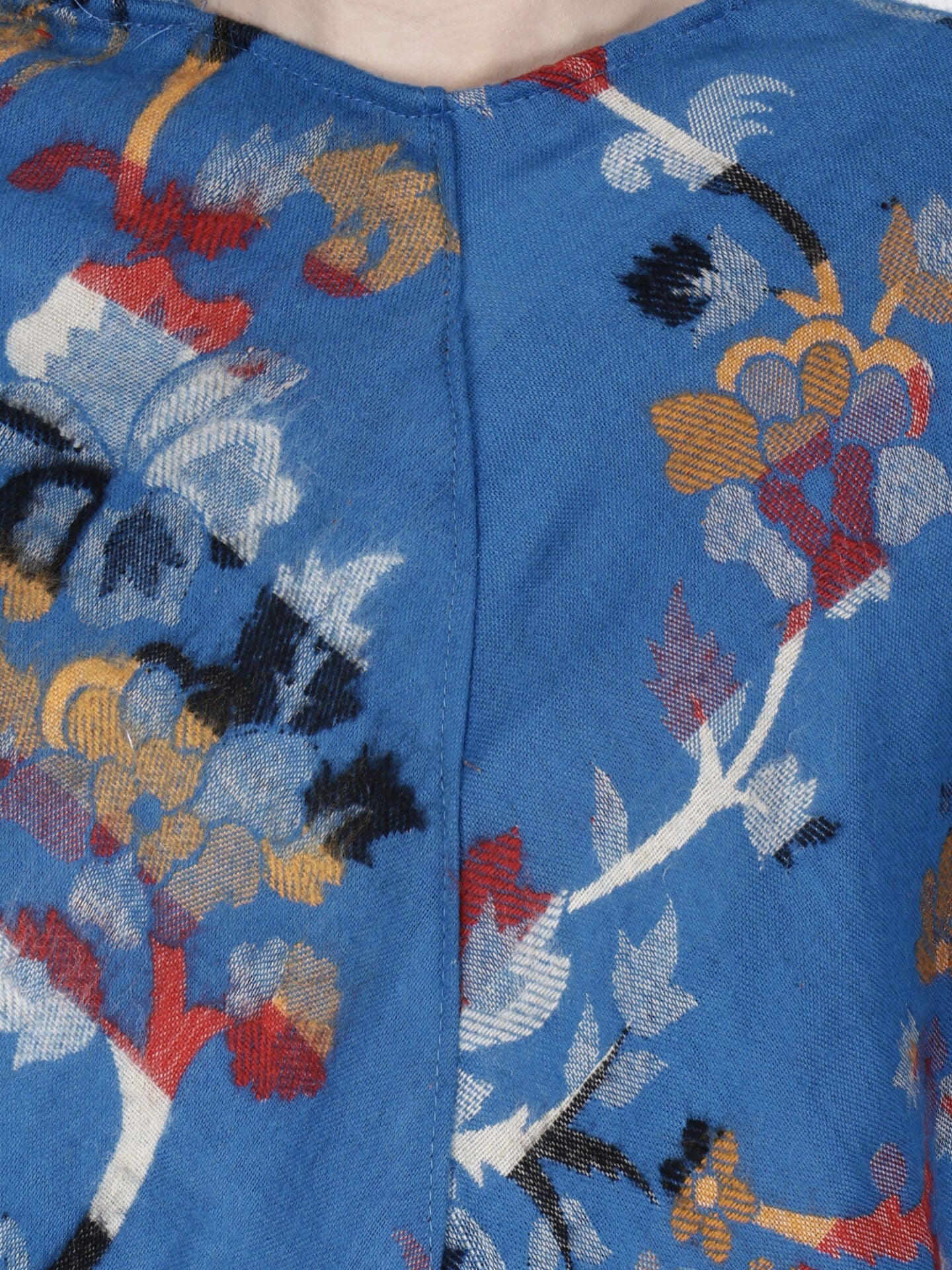 Close-up of the blue Kashmiri poncho woolen poncho with hood for ladies by aruna kullu handloom, featuring colorful floral patterns and a vertical seam—ideal for showcasing fine embroidery details.