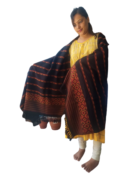 A woman in a yellow kurta and white leggings stands barefoot, draped in the aruna kullu handloom Hand Woven PASHMINA BLACK Shawl—beautifully embroidered for women—against a plain white background.