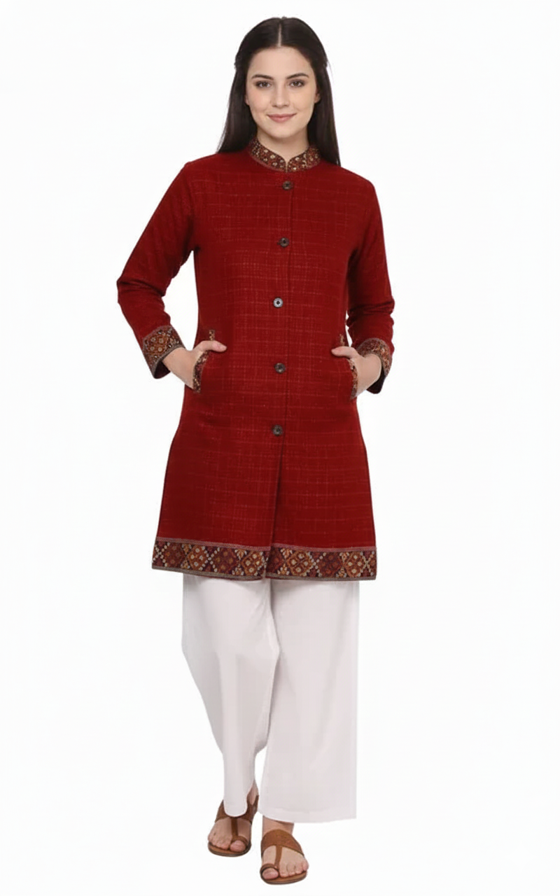 A woman smiles with her hands in her pockets, styled in an "aruna kullu handloom" himachali Long Jacket for ladies, featuring red check and full sleeves, over a red kurti and white pants, against a white background.