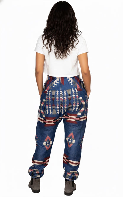 A person with long wavy hair, wearing aruna kullu handloom's Wool Super Soft Warm Pajamas WITH KULLU PATTI WORK in blue, stands facing away from the camera against a plain white background.