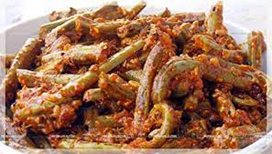 A close-up of Lingdu Ka Achar by aruna kullu handloom, featuring fiddlehead ferns (Kasrod) coated in a rich, reddish-brown spice and tomato mix, capturing the vibrant flavors of traditional Kasrod Ka Achar.