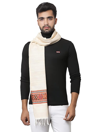 A man in a black long-sleeve shirt and white pants stands with the aruna kullu handloom "kullu muffler Woollen Hand Woven Pure Embroidered Muffler white multi" draped over his shoulder. The background is plain white.
