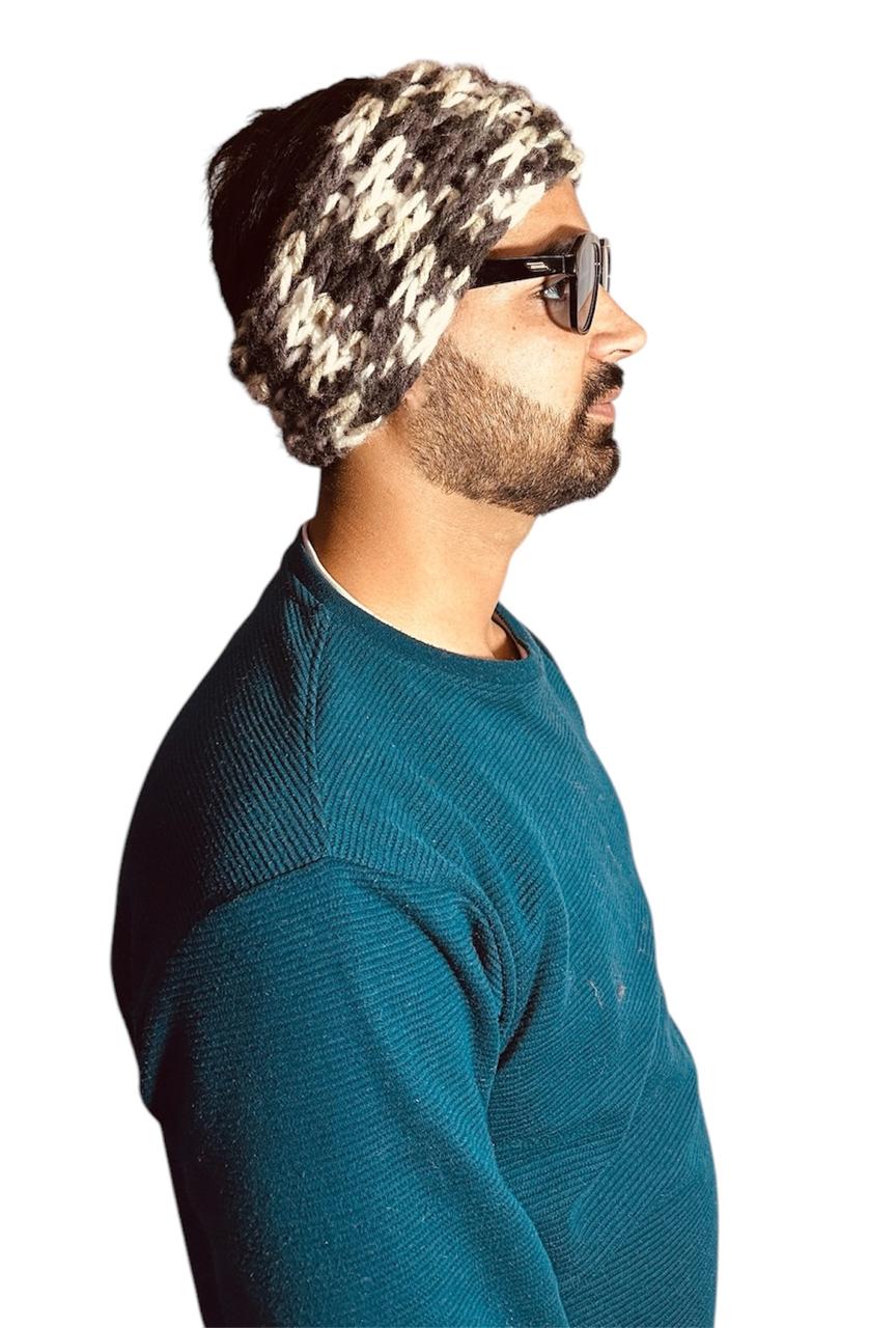 A man in a blue sweater and sunglasses is shown in profile, wearing an aruna kullu handloom woolen headband PACK OF 3 PCS. with a black and white pattern. The background is plain white.