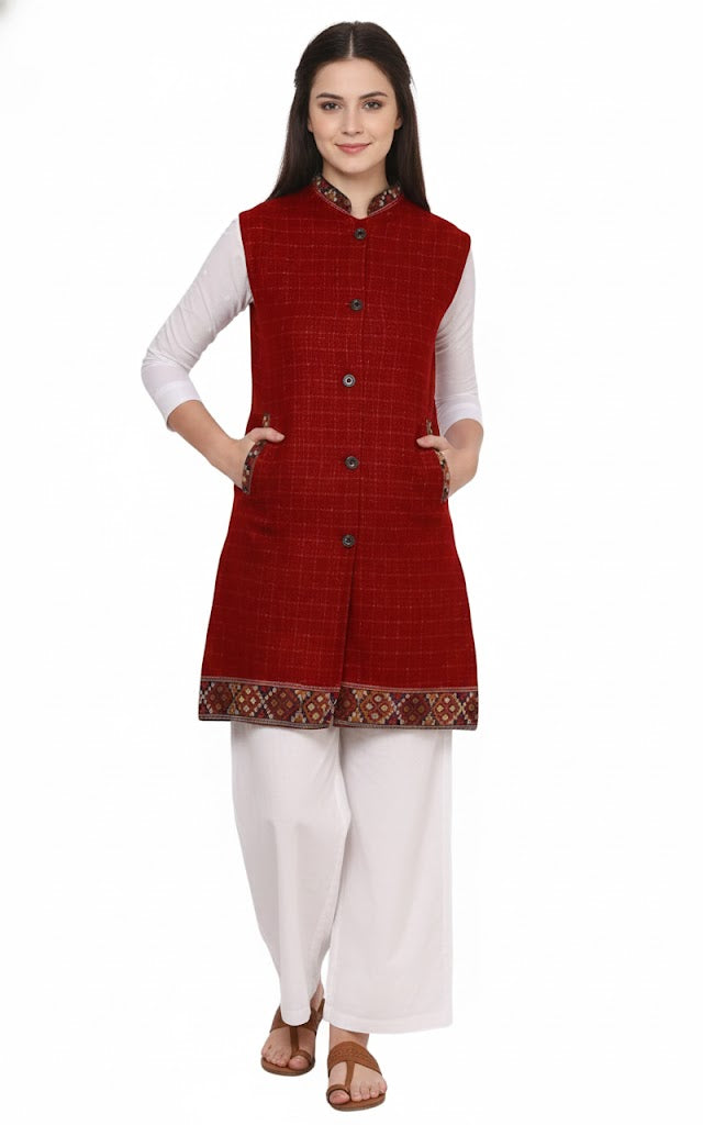 A woman with long dark hair wears a white kurta and palazzo pants, styled with the aruna kullu handloom Check red long jacket featuring kullu lace work and buttons. She stands facing forward, hands in pockets, against a white background.