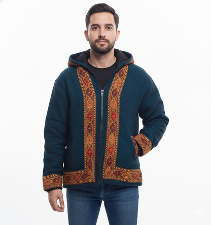 A man with short dark hair and a beard wears an aruna kullu handloom Woolen Winter Wear ZIPPER HOODIE Jacket for men in sapanish blue with Kullu Patti work, standing against a plain white background.